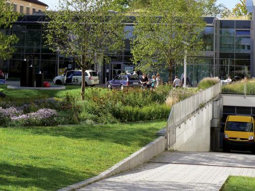 Lieferwagen fährt aus einer üppig begrünten Tiefgarage heraus